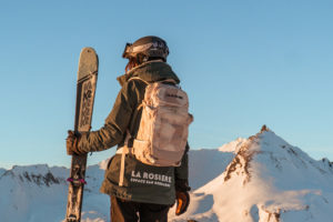 Skieuse portant un sac à dos Dakine et des skis k2